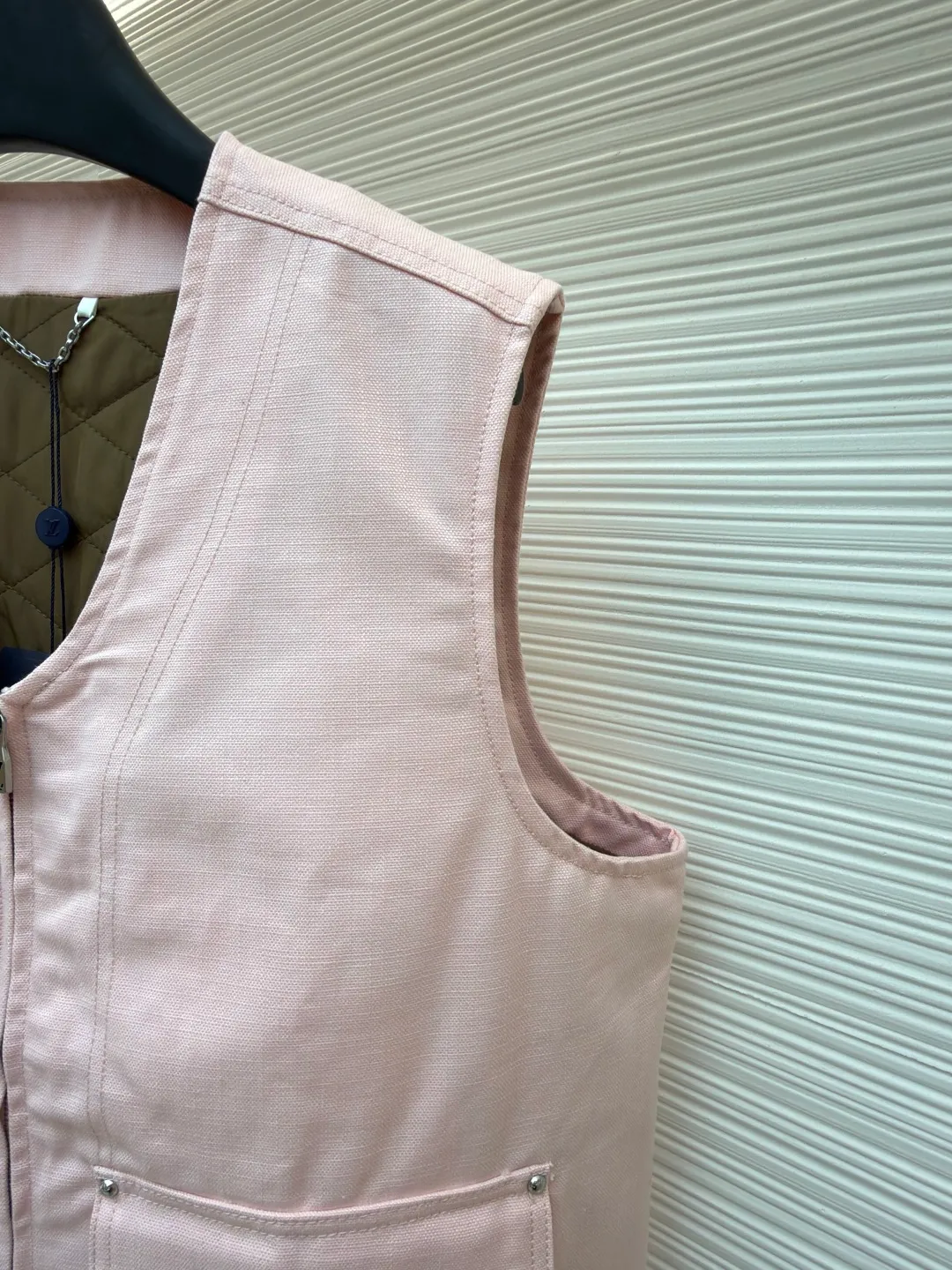 LOUIS Vuitton ●Description: This vest is made of high-quality cotton and linen blended fabrics, and the main tone of pink gives it a soft and fashionable feel. It has a V-neck design and a metal zipper placket, which is smooth and has industrial style details. The double patch pockets on the front chest have a three-dimensional structure, and the pockets are double-fastened with metal rivets and buttons to enhance practicality and decoration. A brand leather label is also embellished on the bottom of the bag to enhance recognition. The interior is quilted and the cotton batting is evenly distributed to ensure warmth and avoid clumping. The seams of the body are made of flat stitching + hemming technology, and the stitching is neat and firm, demonstrating exquisite workmanship. The overall shape is loose and moderate, combining the toughness of work clothes with the casualness of daily wear. From fabric selection to detail sewing, every craftsmanship takes into account both style expression and wearing experience. The overall wiring is straight and delicate, the fabric is comfortable and soft, and the color is consistent without color difference. It can be matched with the same style to create a fashionable look and control various occasions. Customized accessories, complete with three standards, same style for men and women!